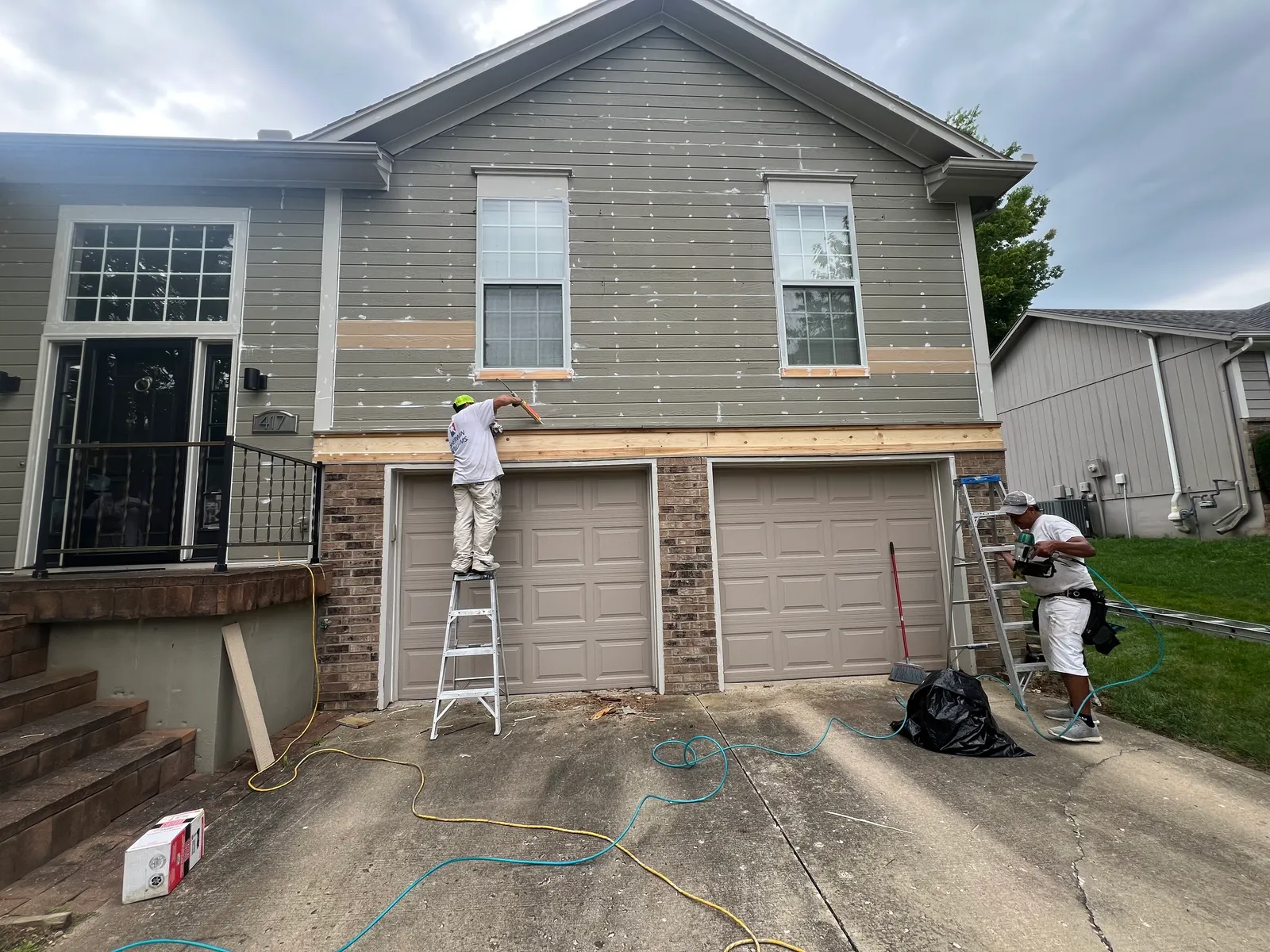 Exterior siding being prepped above garage